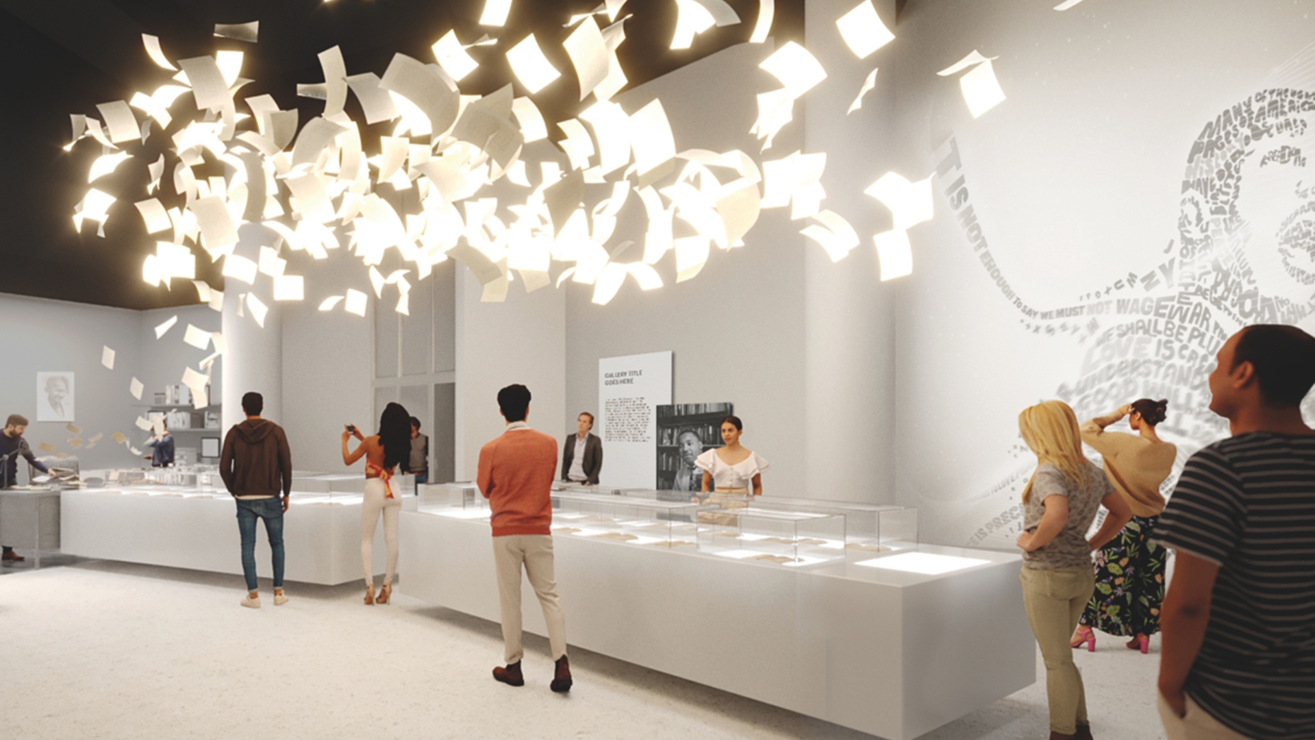 Visitors explore a bright exhibit featuring a cluster of illuminated floating papers suspended from the ceiling. The room includes glass display cases and a mural on the wall with text forming the shape of a person’s face. Visitors are engaged with the artwork, some taking photos.